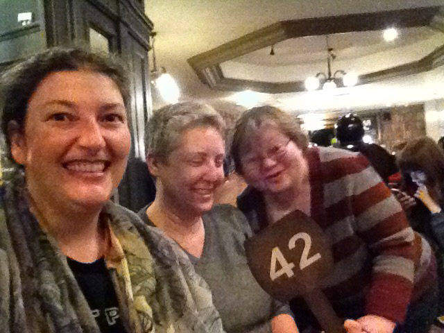 Three friends at a cafe enjoying the coincidence of being given a 42 cafe number.
